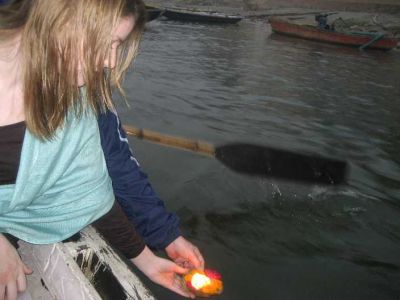 Liz placing a candle into the Ganges